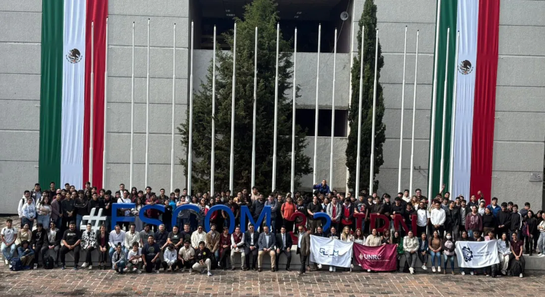 Group photo of hackathon students, mentors, and judges in front of the large #ESCOM letters and the Mexican flag.